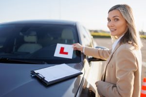 Driving Instructor placing L Plate on car